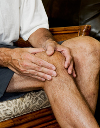 man massaging knee with apparent pain