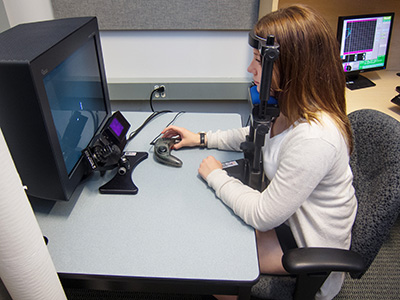 Neuroscience graduate student Kaity Lalonde demonstrates the "eye soccer" experiment that measured the eye movements of schizophrenia patients. Photo: Brian Kladko