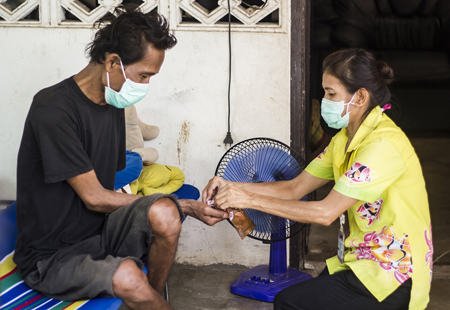 A tuberculosis patient in Thailand receiving therapy during a home visit. Photo: USAID Asia