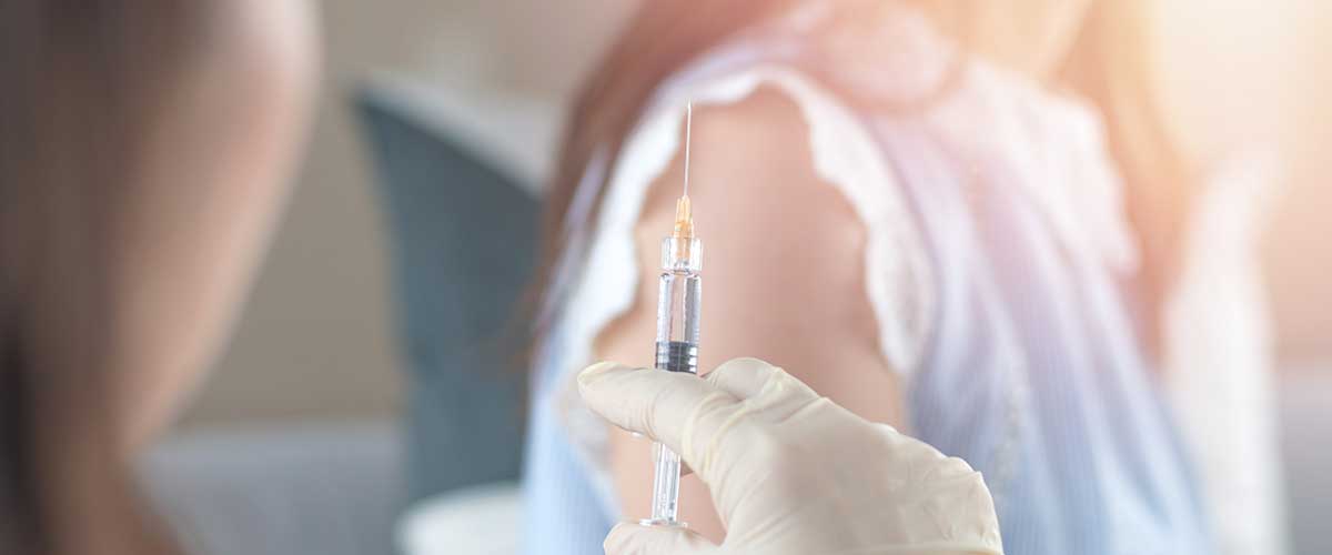 Needle with vaccine prepared for a young woman