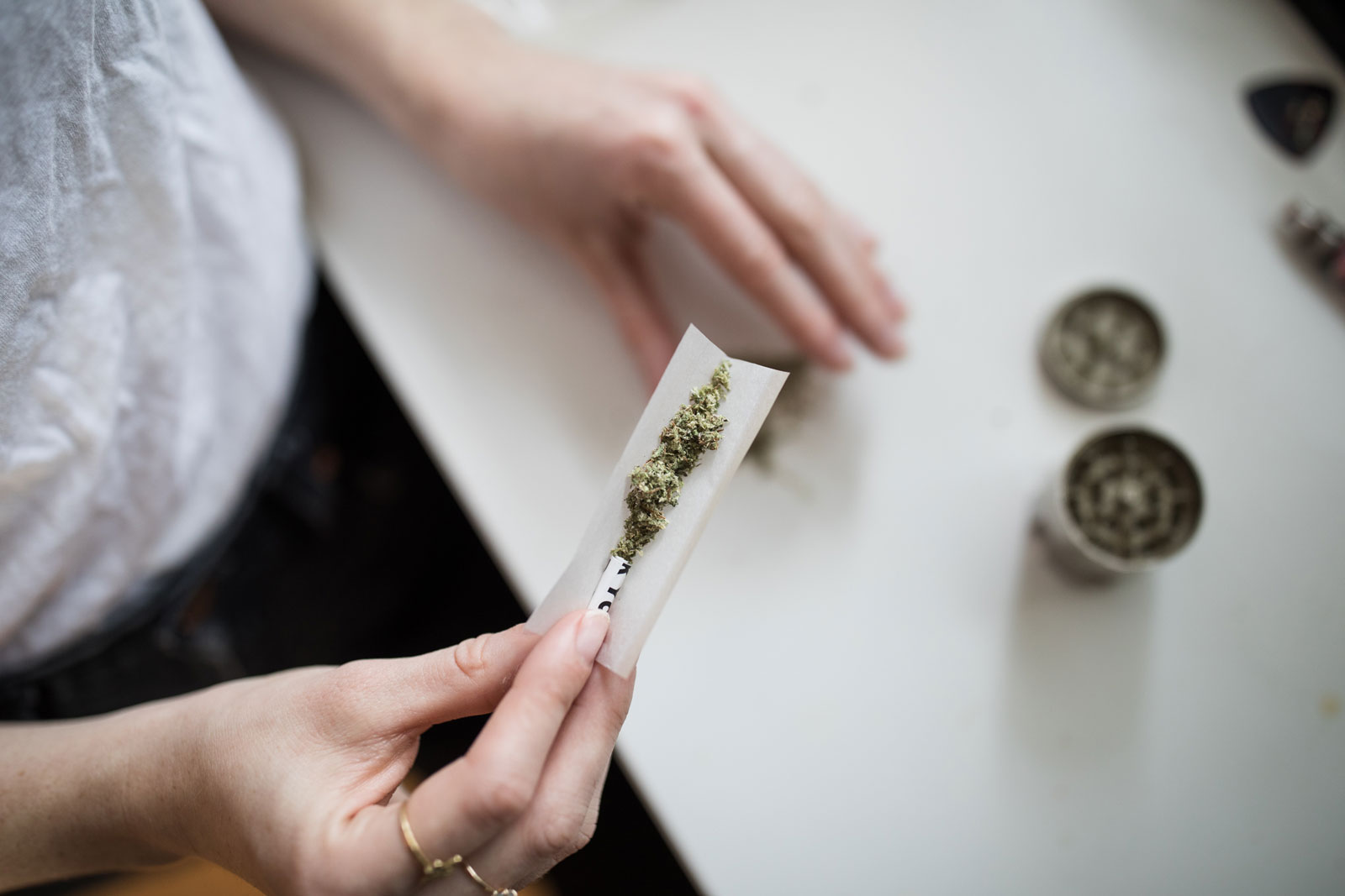 Woman rolling cannabis with rolling paper