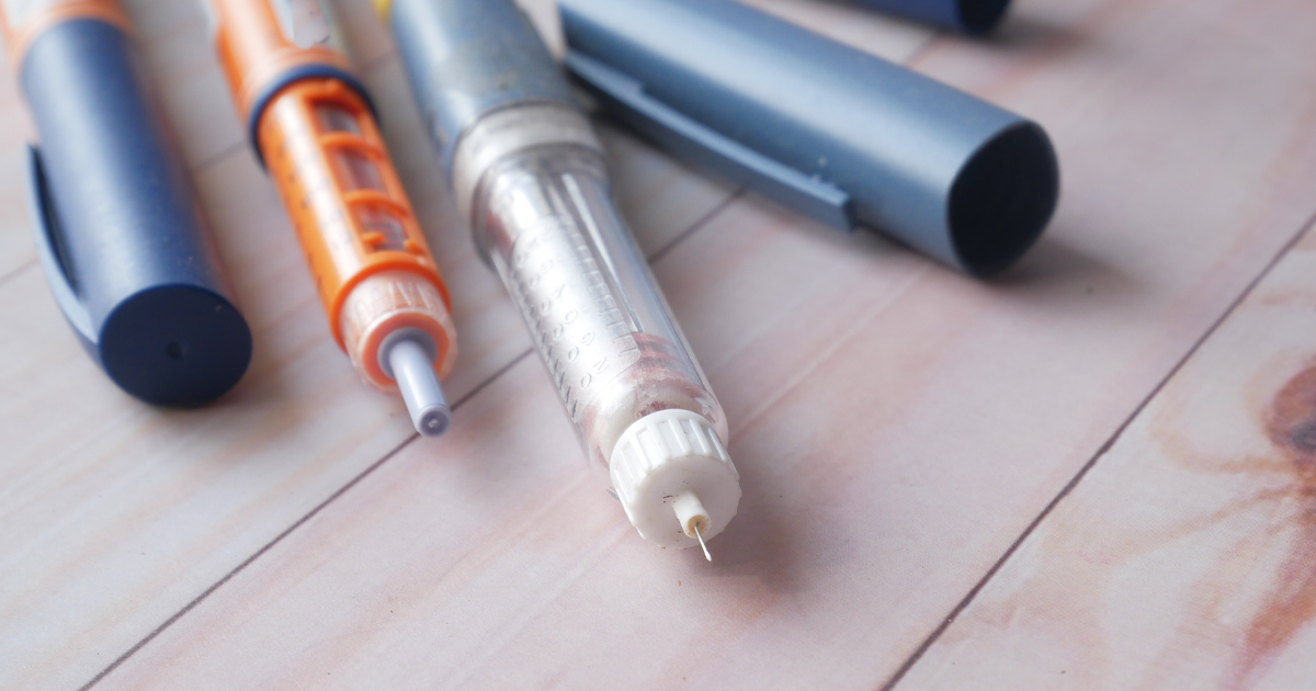 A close up image of insulin pens on wooden background.