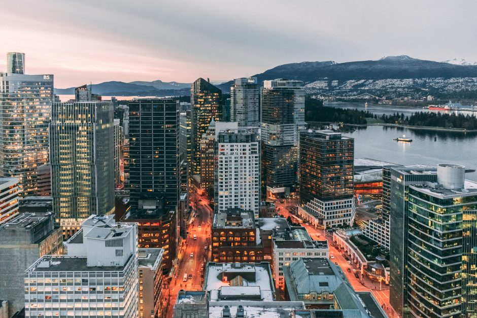 Photo of downtown Vancouver with the ocean and snow-capped mountains in the background. 